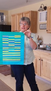 Jen Johnson displays a mod quilt made with 5 colors only.